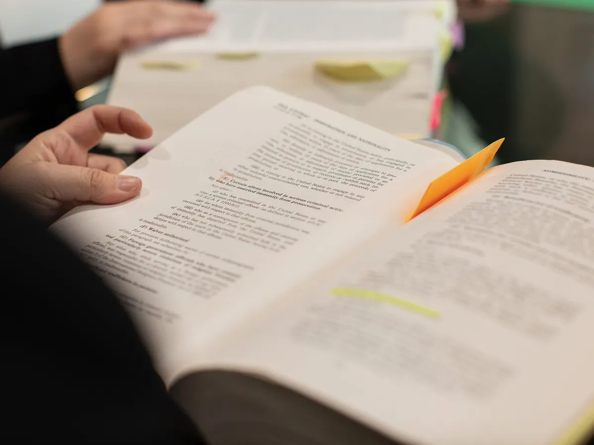 Libro de normativa abierto con pestañas de colores marcando los apartados